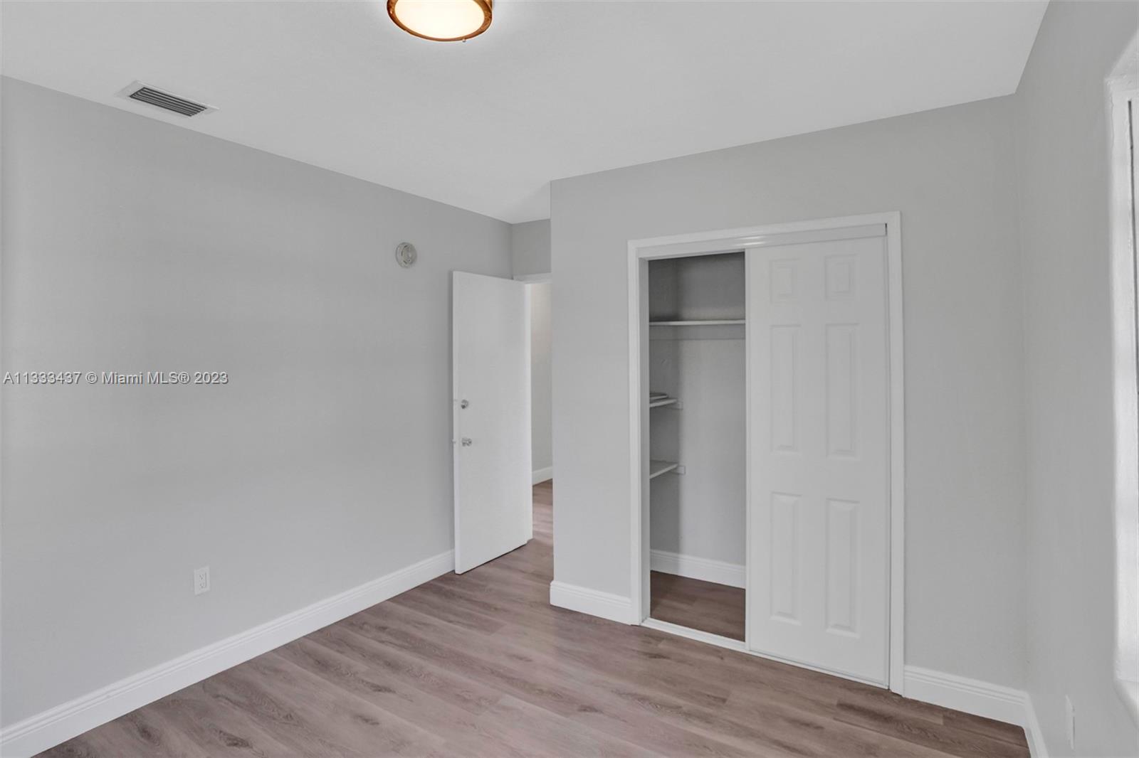 1101 Northwest 147th Street Miami, FL 33168 - Photo 24 of 45 a view of an empty room with wooden floor