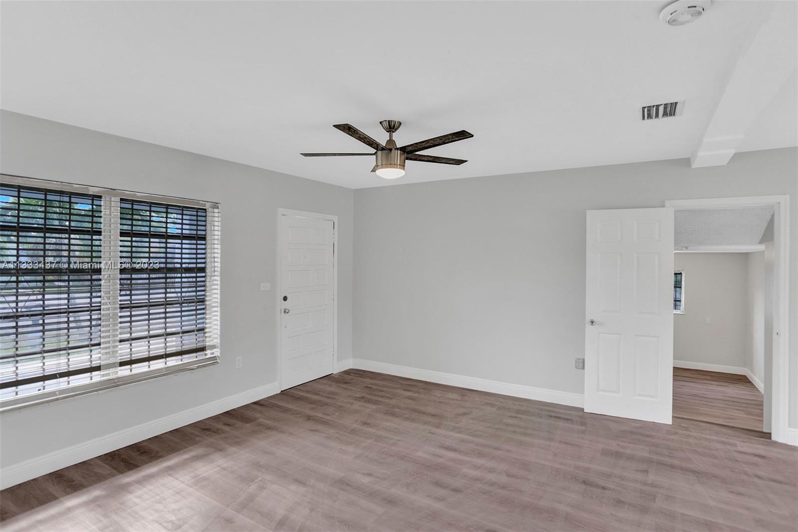 1101 Northwest 147th Street Miami, FL 33168 - Photo 8 of 45 an empty room with wooden floor and ceiling fan