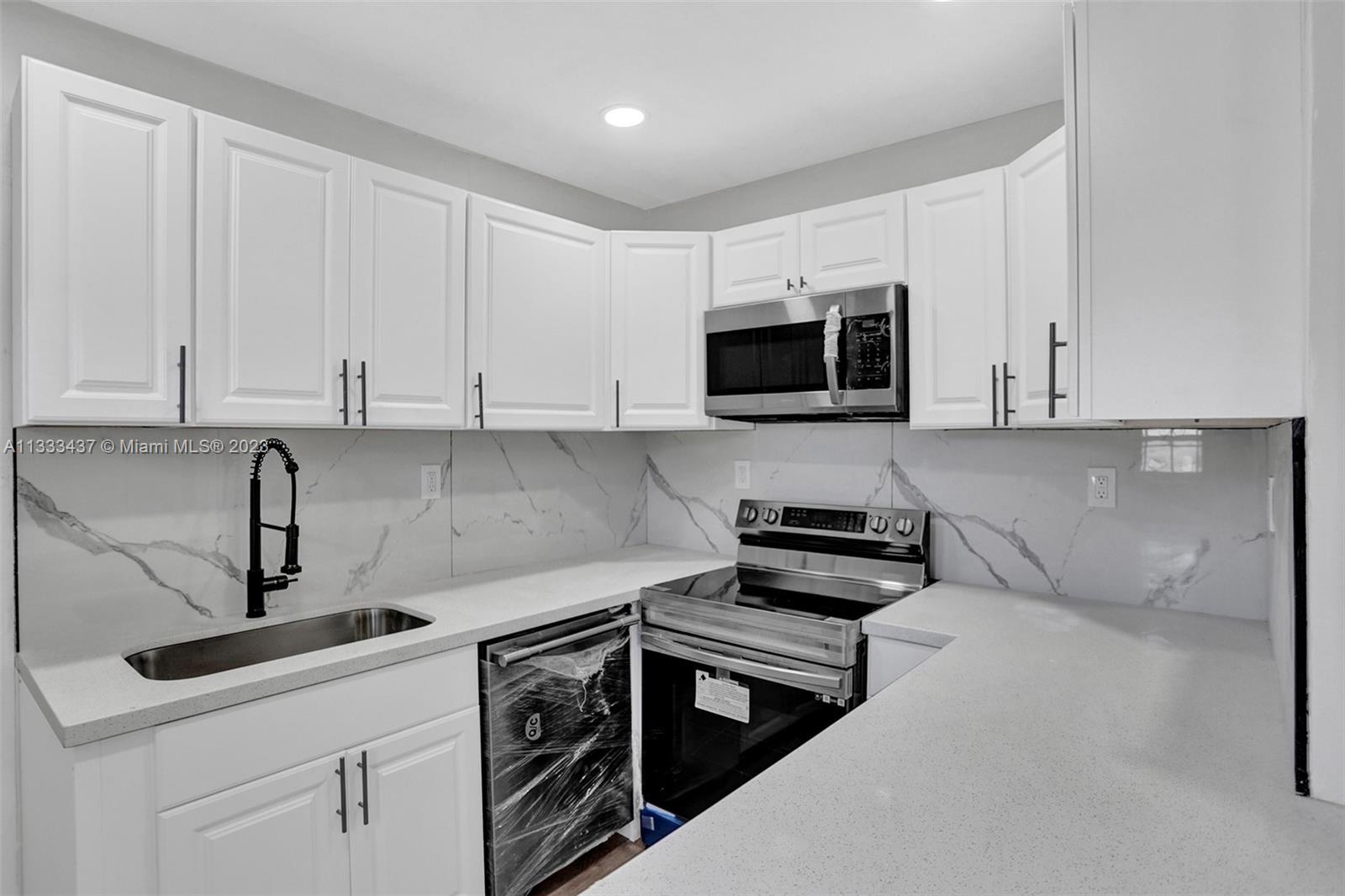 1101 Northwest 147th Street Miami, FL 33168 - Photo 9 of 45 a kitchen with appliances a sink and cabinets