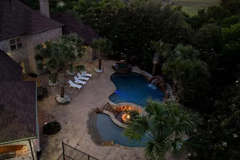 an aerial view of a house with yard swimming pool and outdoor seating