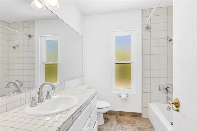 a bedroom with a bed ceiling fan and a window