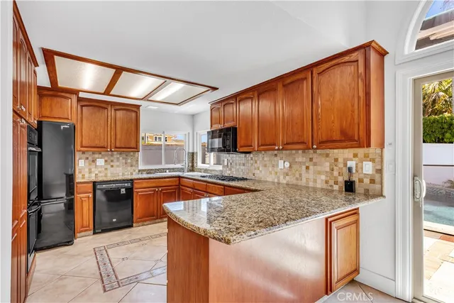 a kitchen with granite countertop a sink stove and refrigerator