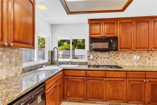 a kitchen with stainless steel appliances kitchen island granite countertop a refrigerator stove and sink