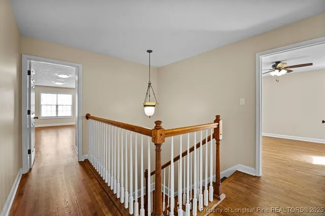 a view of a hallway with wooden floor and stairs