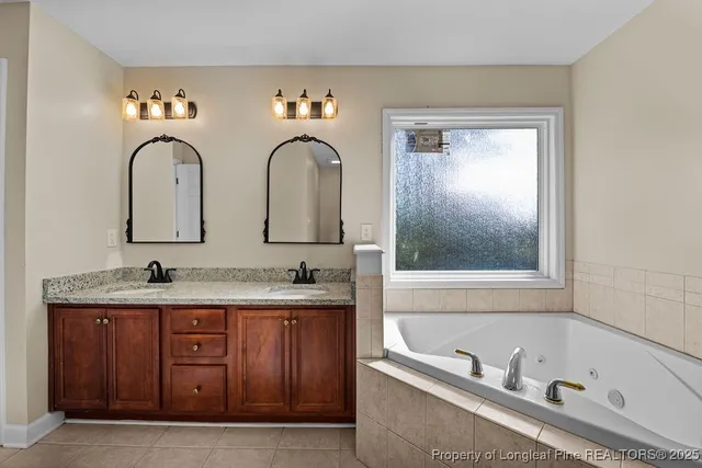 a bathroom with a tub and double sink