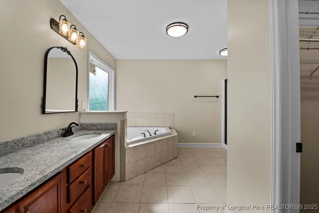 a spacious bathroom with a granite countertop sink and a mirror