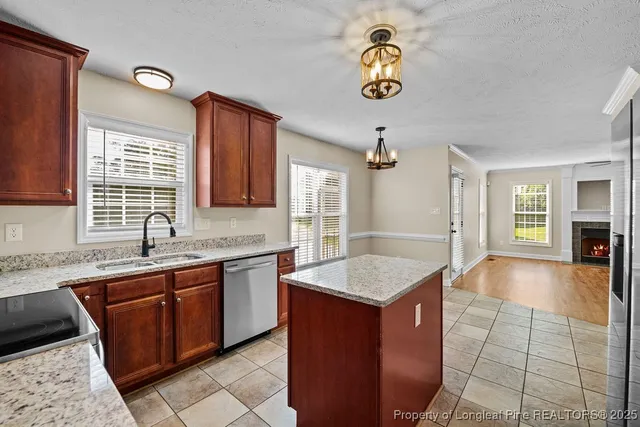 a hall with kitchen island granite countertop a sink a counter top space and appliances