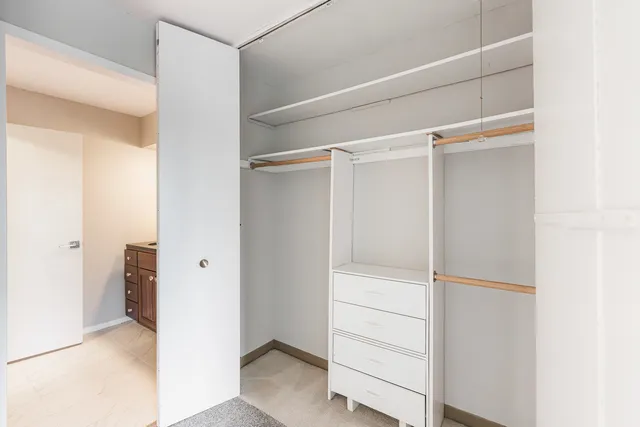 a view of walk in closet with empty racks