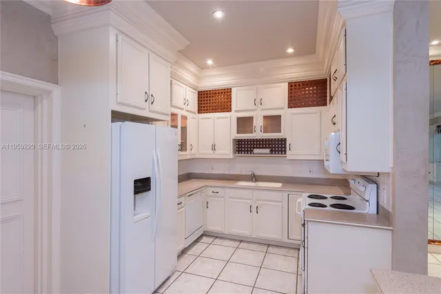 a kitchen with white cabinets and white appliances