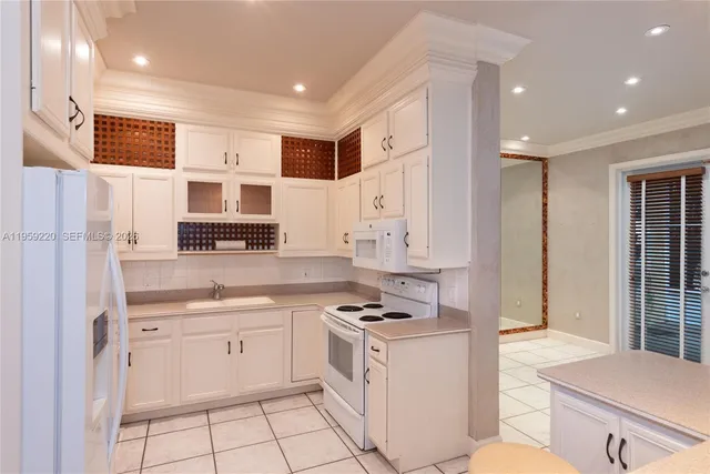 a kitchen with white cabinets and appliances