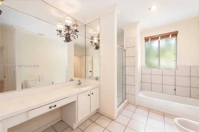 a bathroom with a double vanity sink mirror and bathtub