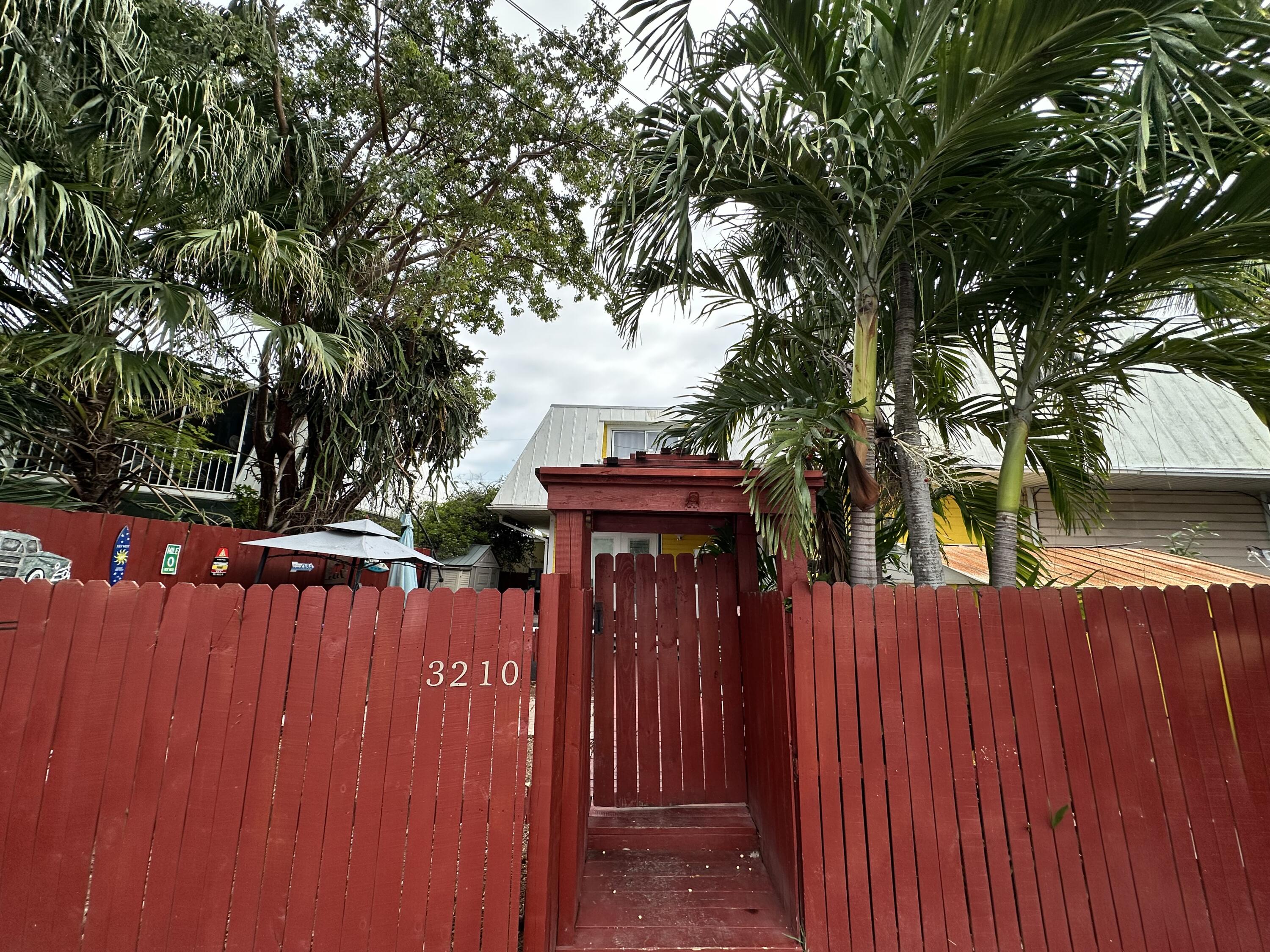 3210 Eagle Avenue Key West, FL 33040 - Photo 28 of 35 a view of a pathway of a house with wooden fence and large trees