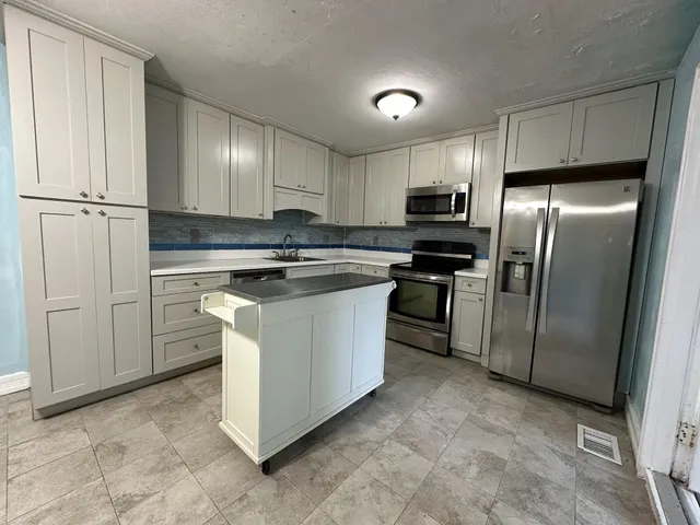 a kitchen with cabinets and stainless steel appliances