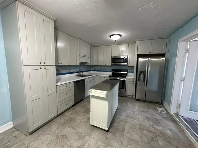a kitchen with a refrigerator stove and sink