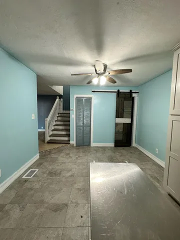an empty room with staircase and fireplace
