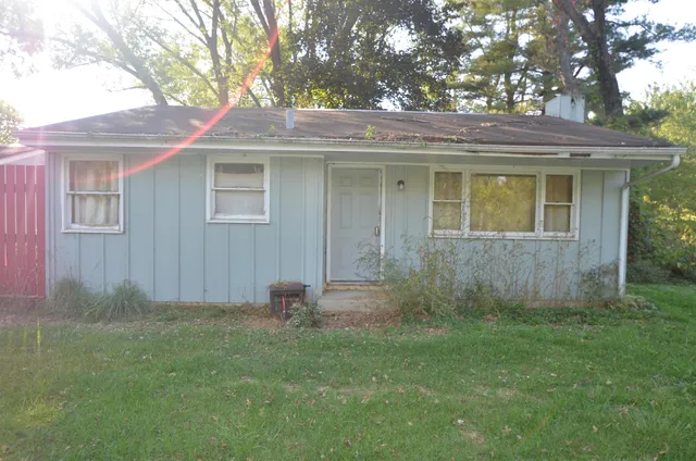 a view of a house with yard and a tree