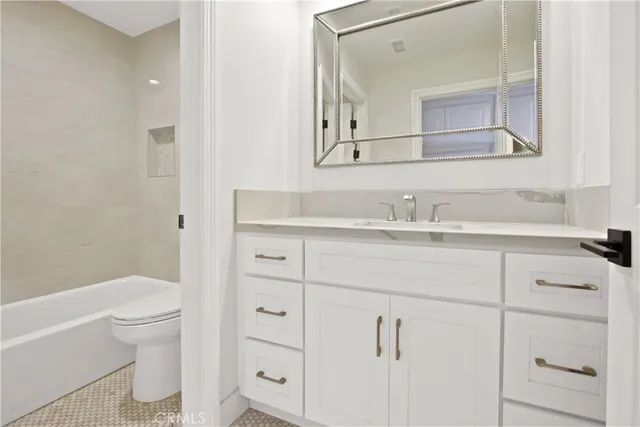 a bathroom with a sink toilet vanity and tub