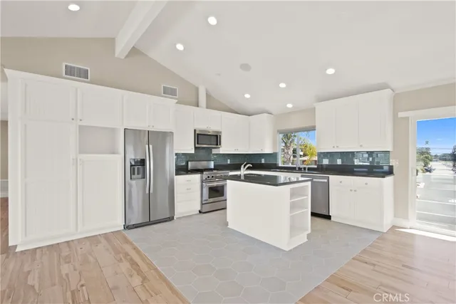 a kitchen with white cabinets and stainless steel appliances