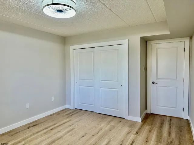 an empty room with wooden floor and closet