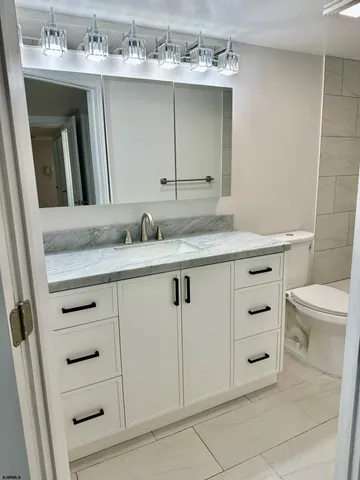 a bathroom with a sink vanity toilet and a mirror
