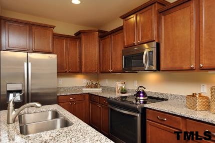 2430 Pecan Ridge Way Apex, NC 27502 - Photo 11 of 23 Actual home will include a Whirlpool stainless gas range, microwave, and dishwasher. Cabinets will be Benton Birch Rouge with El Dorado granite countertops, and a backsplash. Not actual home - photo is of model home.