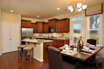 2430 Pecan Ridge Way Apex, NC 27502 - Photo 13 of 23 Enjoy sunny meals at your breakfast bar or dining table! Not actual home - photo is of model home.