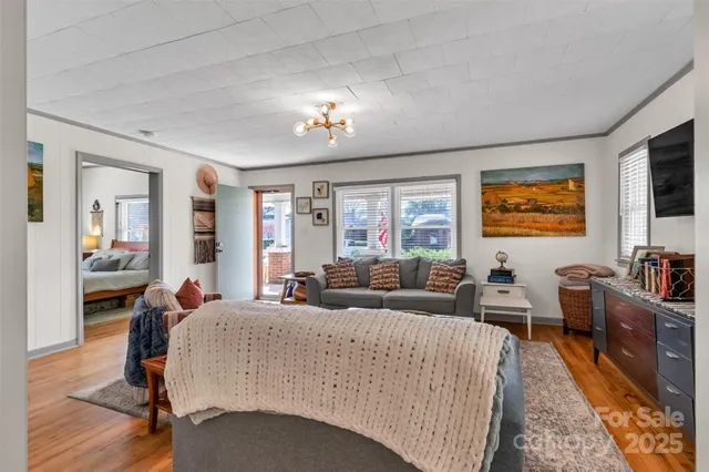a living room with furniture two window and a flat screen tv