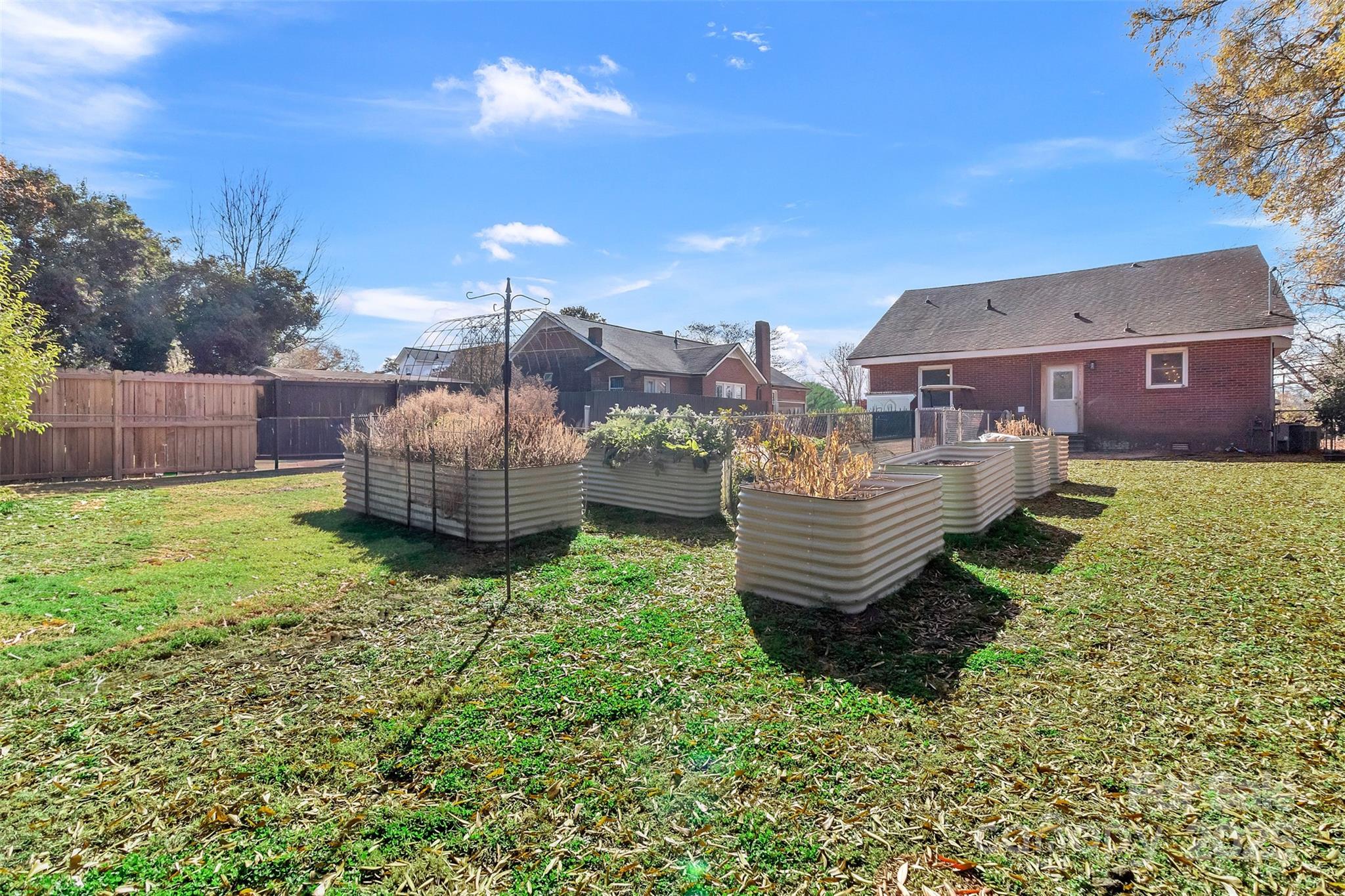 113 Marion Street Clover, SC 29710 - Photo 24 of 26 a backyard of a house with a garden and barbeque oven