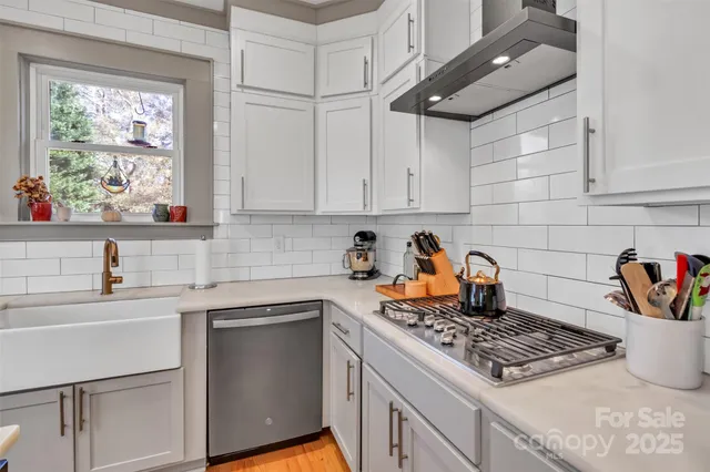a kitchen with stainless steel appliances granite countertop a sink stove and cabinets