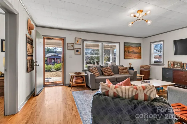 a living room with furniture large window and flat screen tv