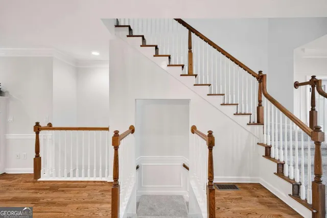 a view of hallway with stairs and wooden floor
