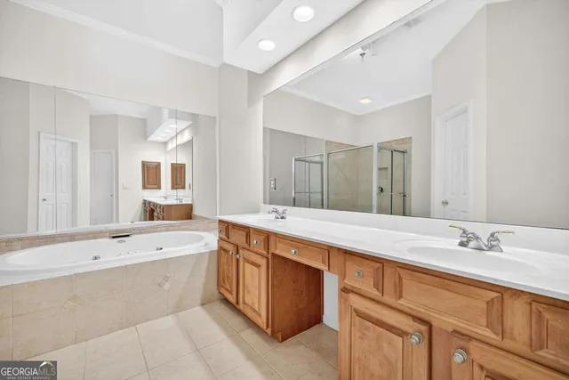 a bathroom with a tub a sink double vanity and mirror
