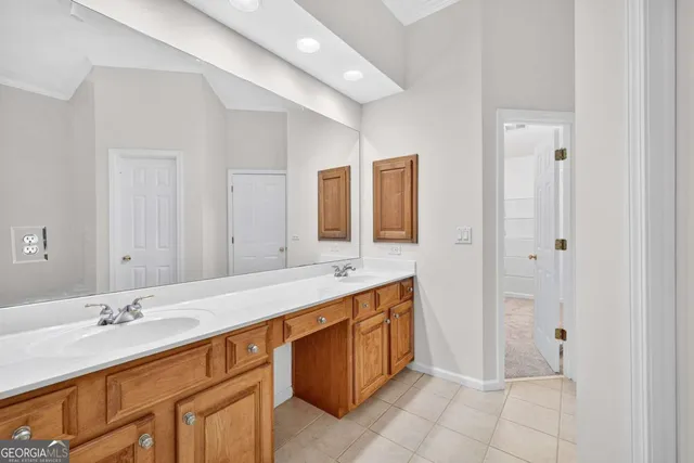 a bathroom with a double vanity sink a mirror and a bathtub