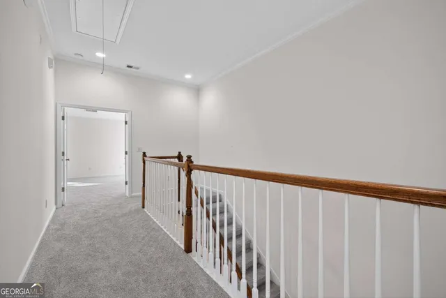 a view of a hallway with wooden floor and staircase