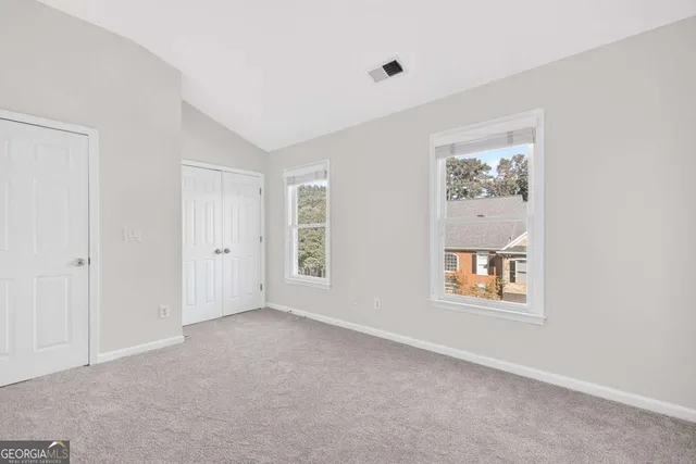 an empty room with windows and closet