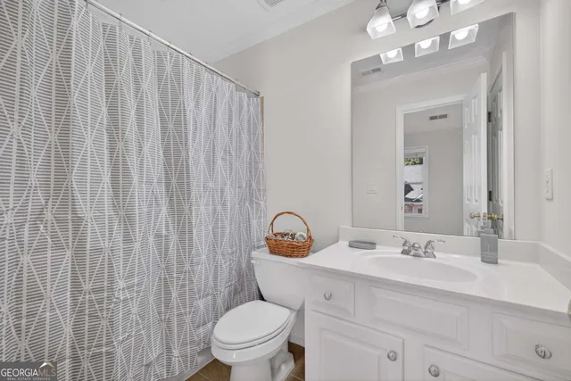 a bathroom with a sink vanity mirror and toilet