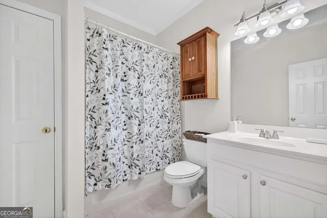 a bathroom with a sink a toilet and shower curtain