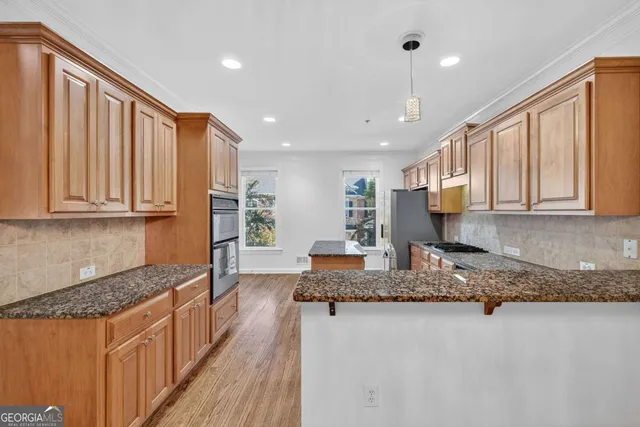a kitchen with stainless steel appliances granite countertop refrigerator sink and cabinets