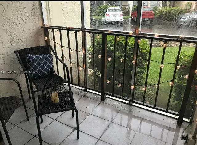 a view of a balcony with chairs and wooden fence