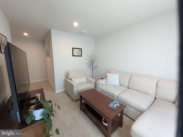 a living room with furniture a couch and a flat screen tv
