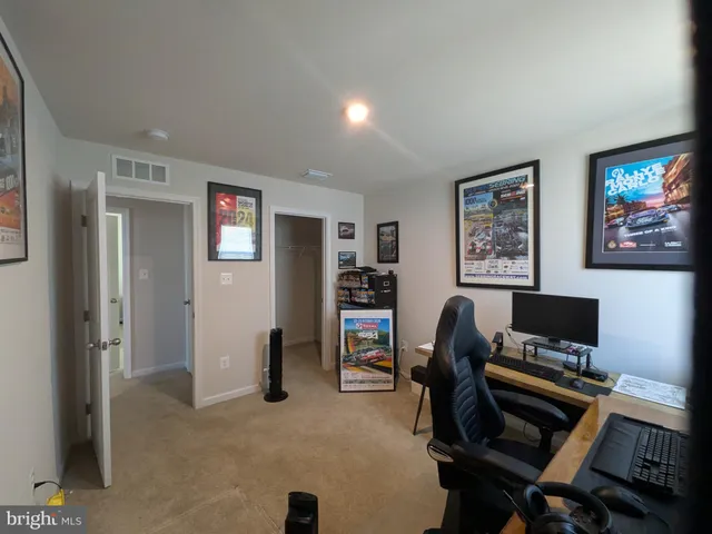 a view of a workspace with furniture and a window