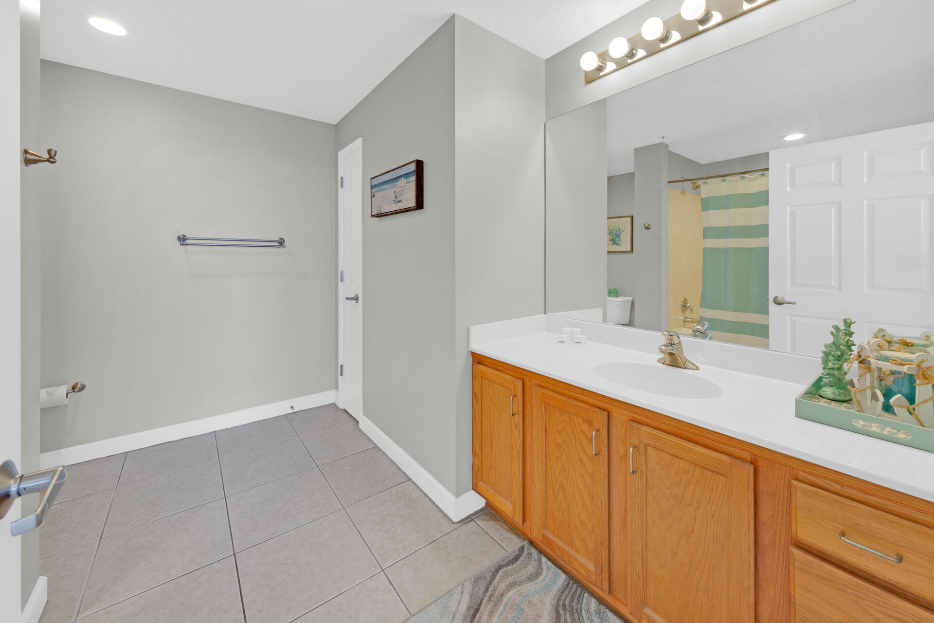12011 Front Beach Road, Unit 701 Panama City Beach, FL 32407 - Photo 18 of 42 a spacious bathroom with a granite countertop sink a mirror and a shower