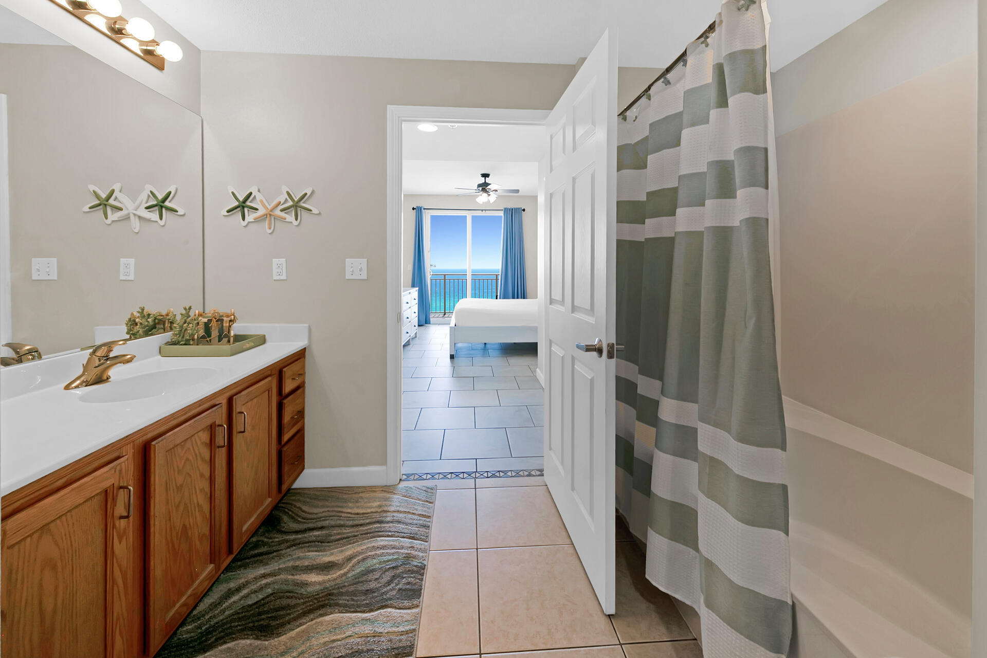 12011 Front Beach Road, Unit 701 Panama City Beach, FL 32407 - Photo 20 of 42 a bathroom with a sink a toilet a mirror and shower