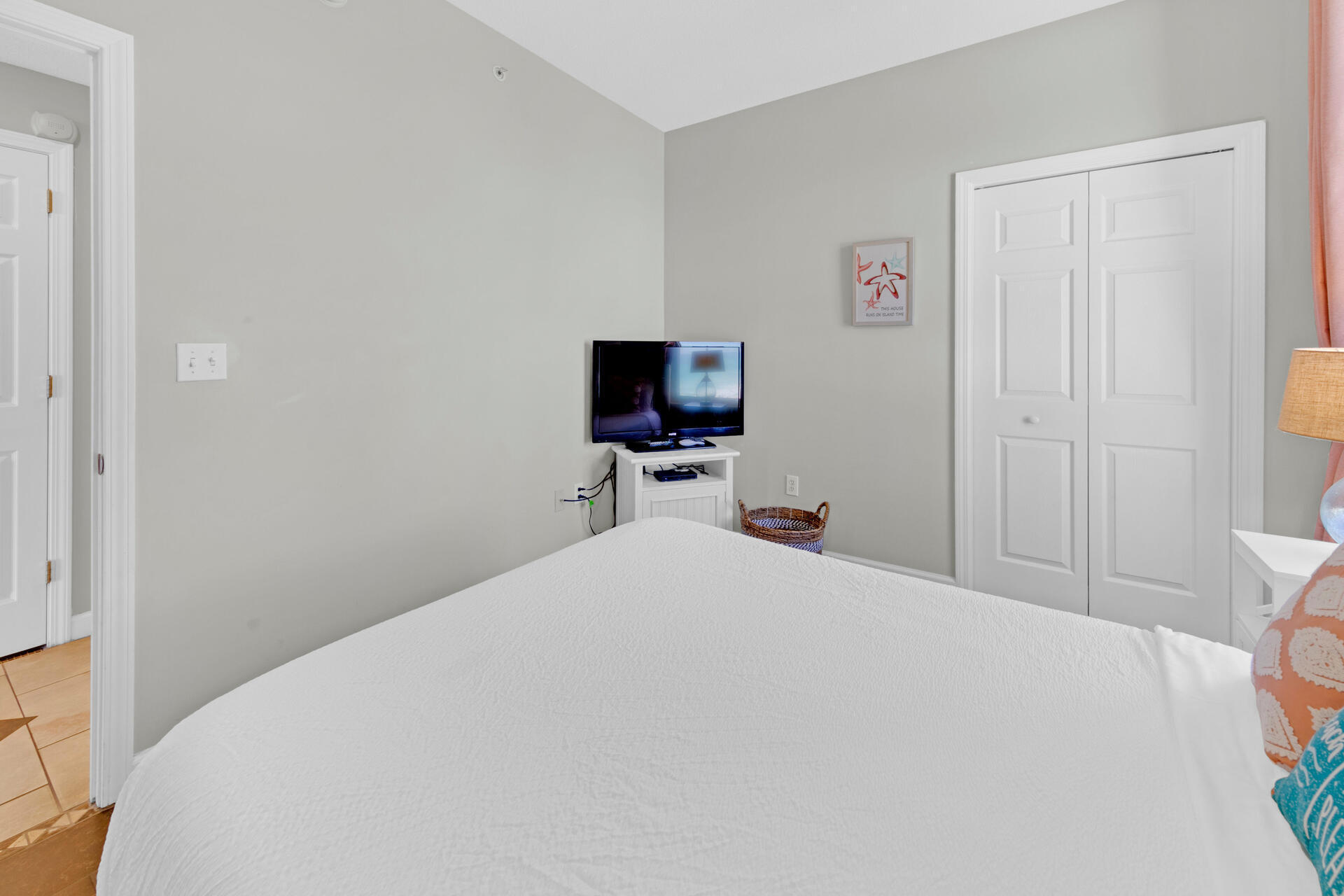 12011 Front Beach Road, Unit 701 Panama City Beach, FL 32407 - Photo 30 of 42 a bedroom with a bed and wooden floor