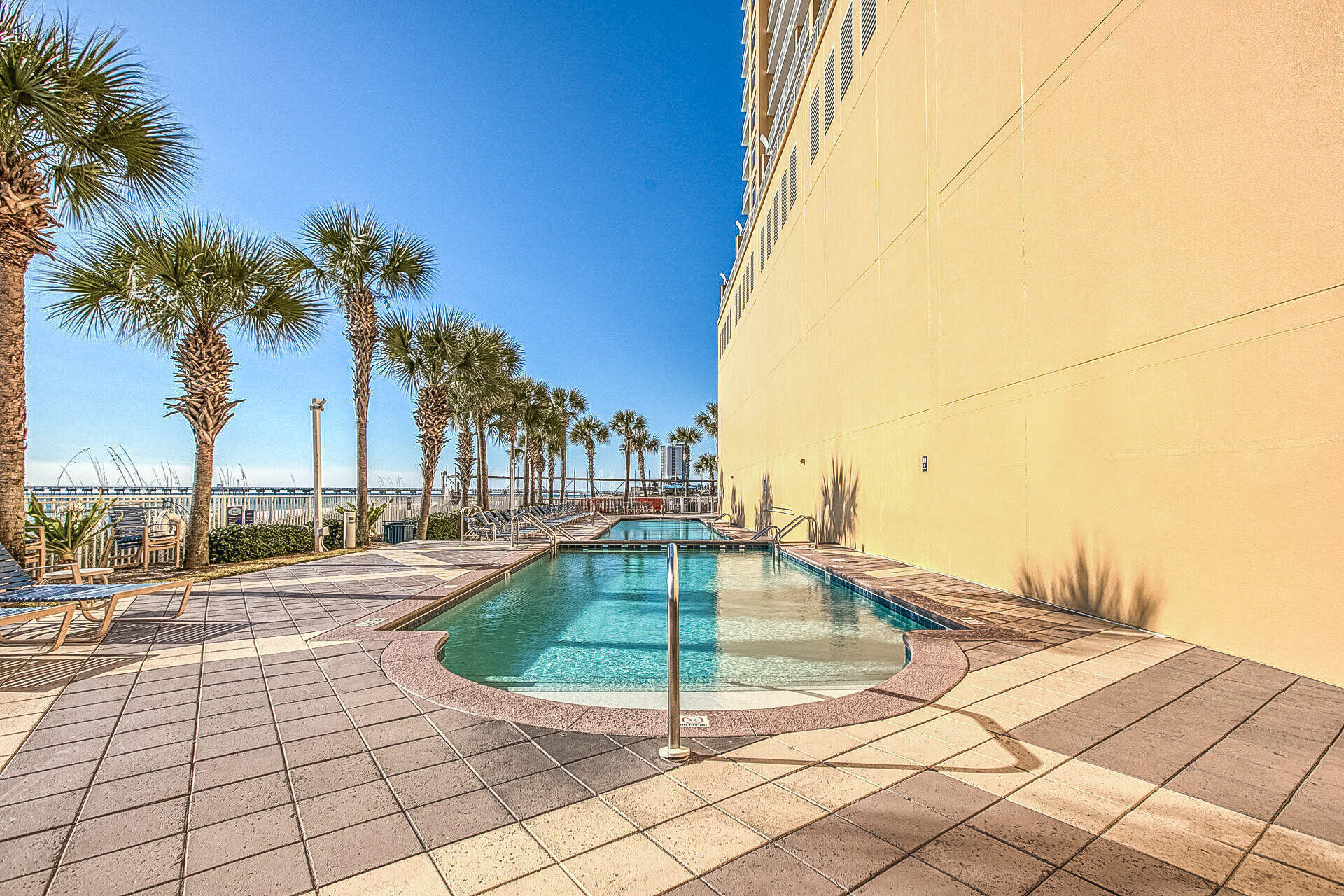 12011 Front Beach Road, Unit 701 Panama City Beach, FL 32407 - Photo 39 of 42 a view of a swimming pool with a lounge chairs
