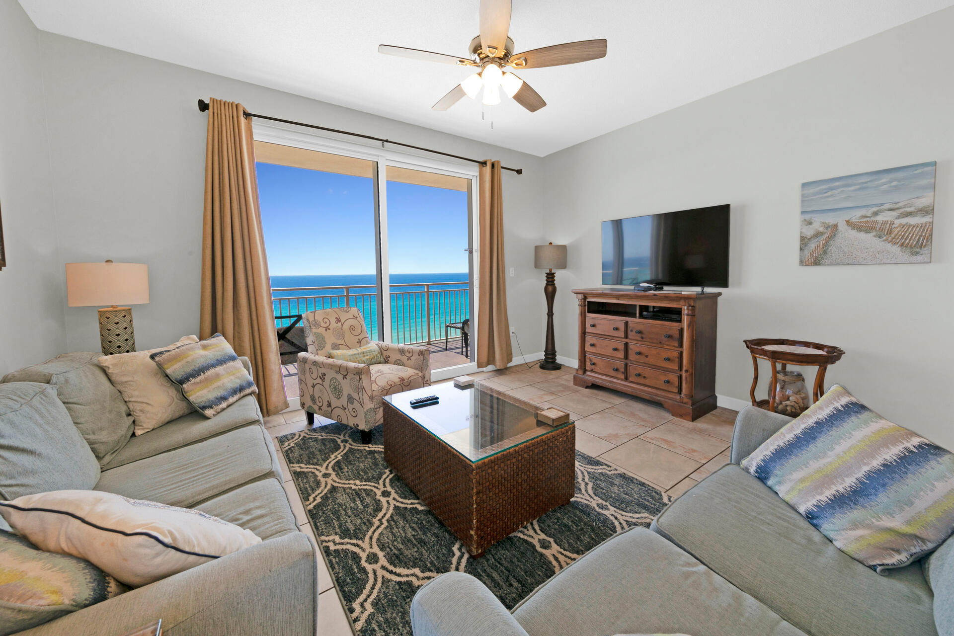 12011 Front Beach Road, Unit 701 Panama City Beach, FL 32407 - Photo 5 of 42 a living room with furniture a flat screen tv and a large window