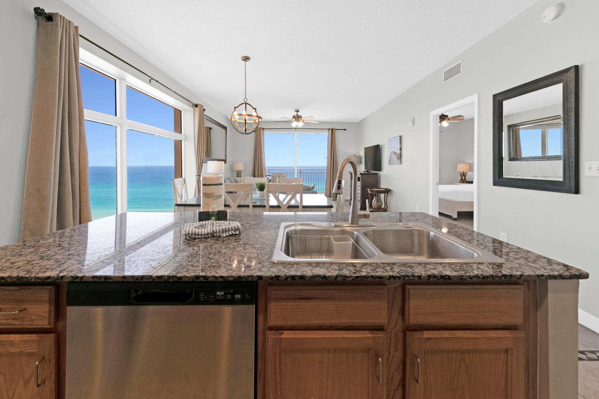 12011 Front Beach Road, Unit 701 Panama City Beach, FL 32407 - Photo 9 of 42 a kitchen with granite countertop a sink stainless steel appliances and cabinets