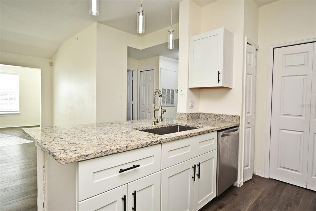 5467 Vineland Road, Unit 6308 Orlando, FL 32811 - Photo 20 of 36 a kitchen with granite countertop granite countertop white cabinets and a granite counter tops