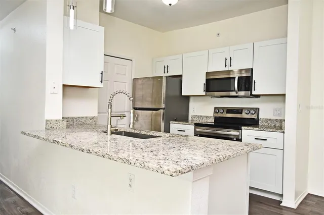 a kitchen with stainless steel appliances granite countertop a sink refrigerator and microwave
