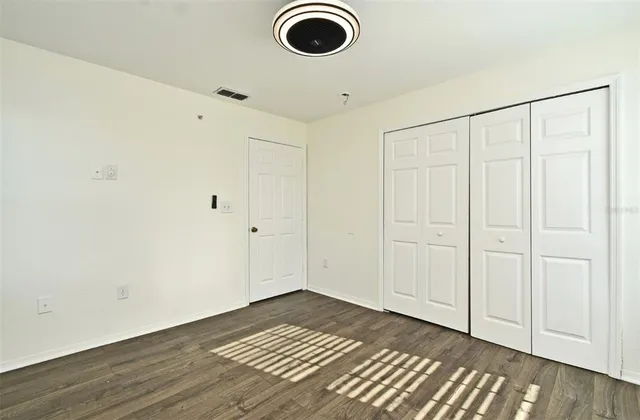 a view of empty room with wooden floor